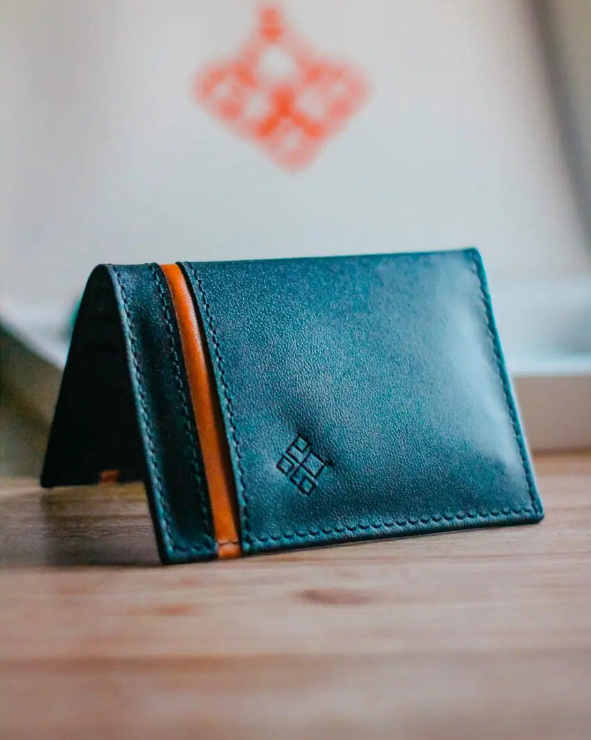 Blue leather wallet with orange stripe on a wooden surface